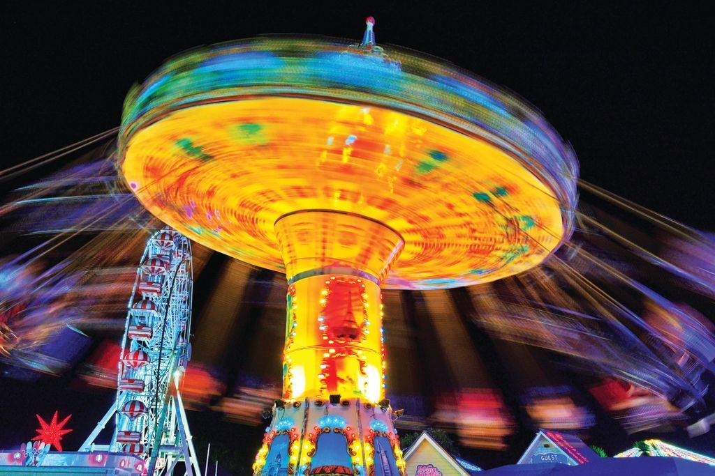 A spinning ride lit up with bright colours at Winter Glow Festival at Adventure Park Geelong.