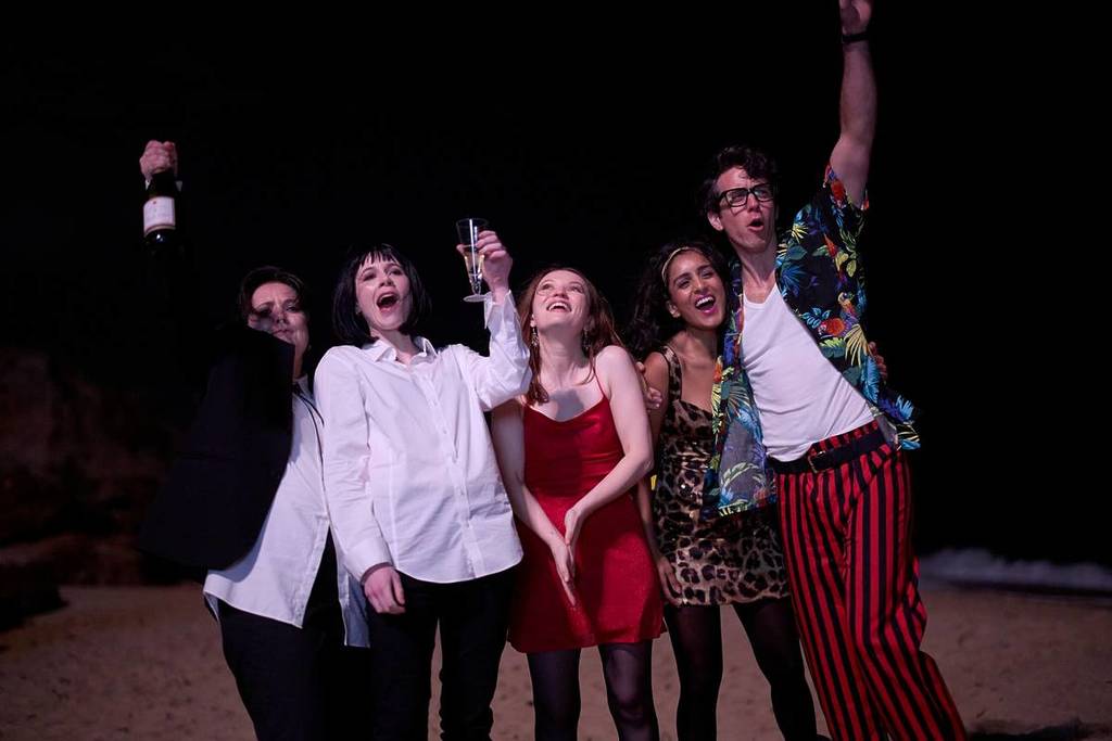 cast of one more shot dancing on a beach