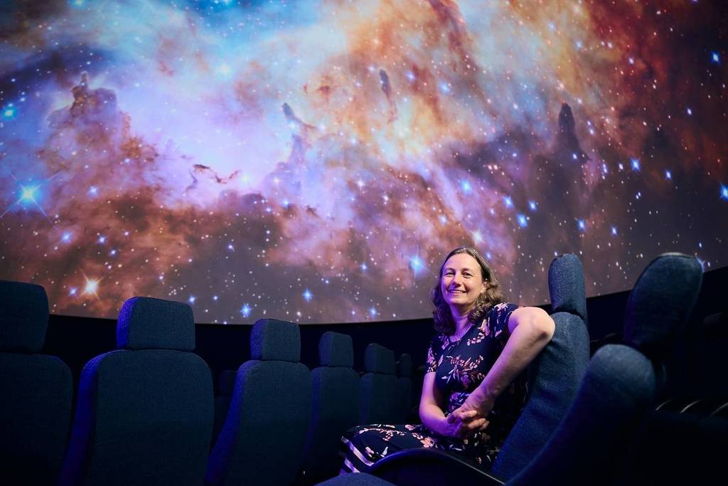 Dr Tanya Hill sitting inside Melbourne Planetarium