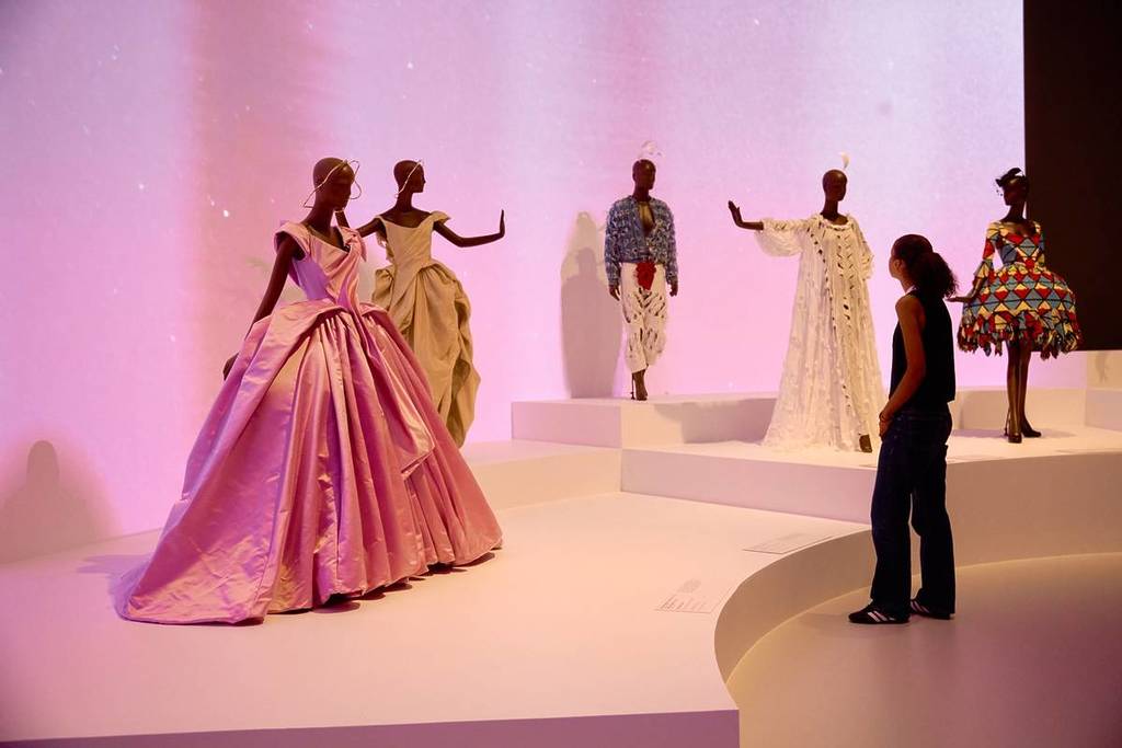 visitor looking at dresses on display in Westwood Kawakubo exhibition
