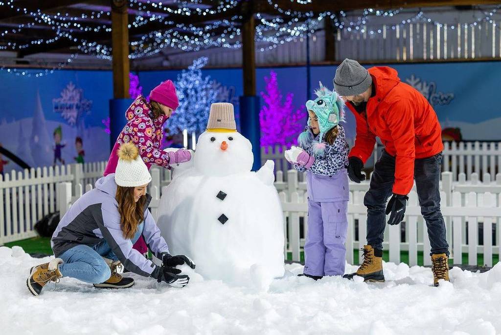 children by a snowman at Adventure Park in Geelong during their Winter Glow festival