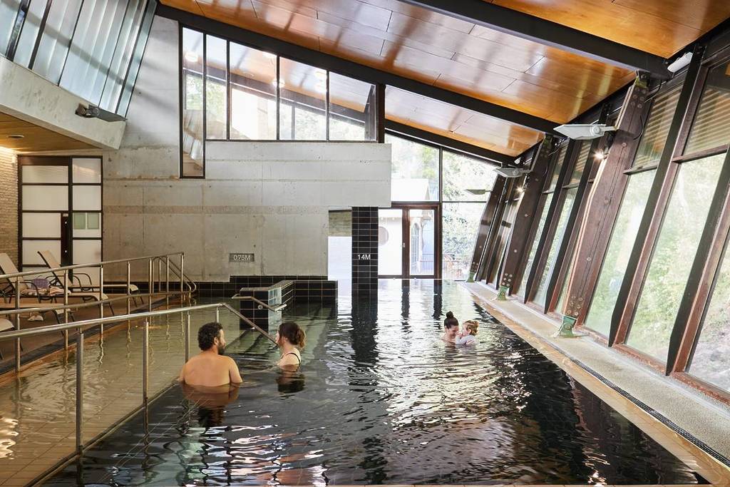 people swimming in the public area of Hepburn Bathhouse & Spa