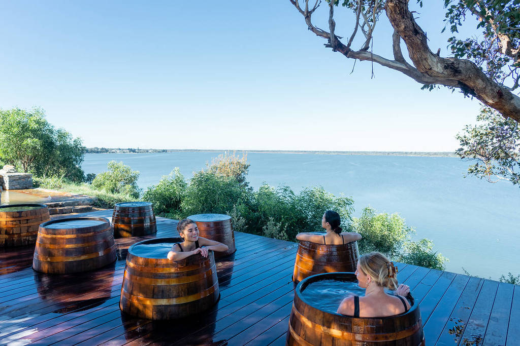 women in bathing barrels looking at the lake view at Metung Hot Spring