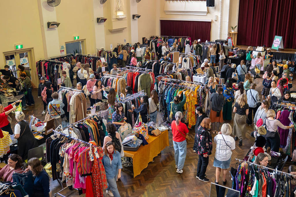 people browsing through racks of clothes at Round She Goes market