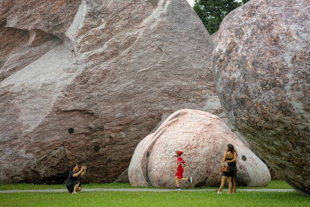 people taking photos of the rocks in day time at the Iwagumi Air Scape installation