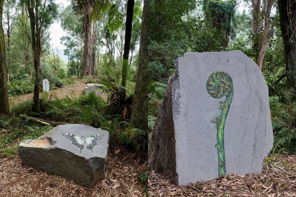 two boulders with artwork of a butterfly and a curled fern in The Reveal, an art trail as part of the ngurrak barring ridgewalk in the Dandenong Ranges