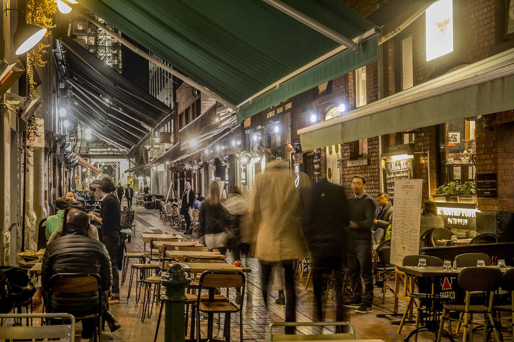 people walking down Hardware Lane at night