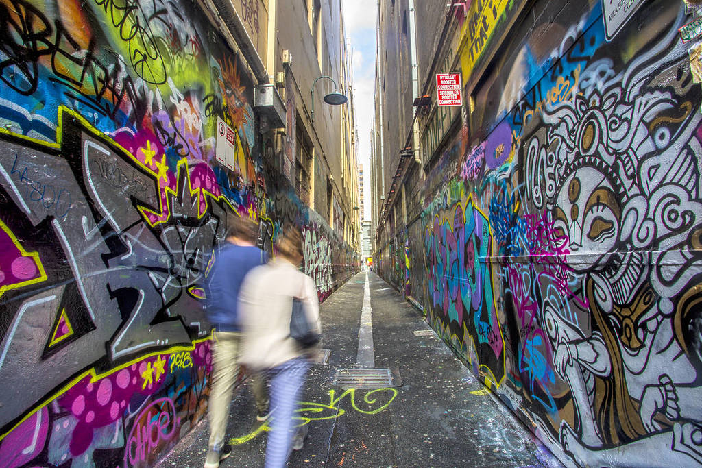 people walking down Union Lane which is covered in street art