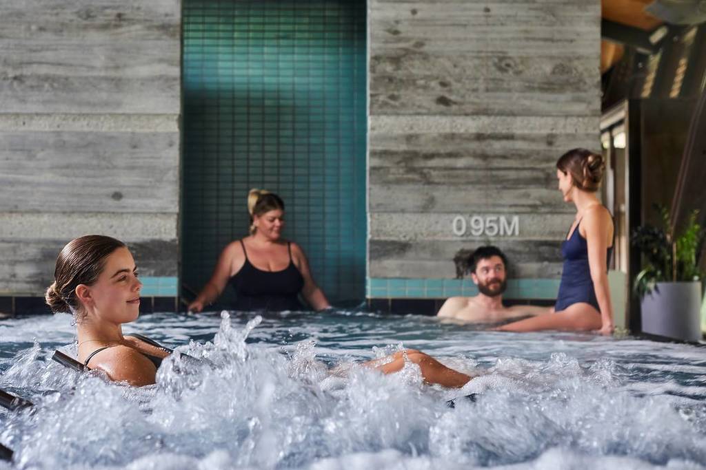 woman relaxing on underwater lounge chair in bubbling pool at Hepburn Bathhouse and Spa