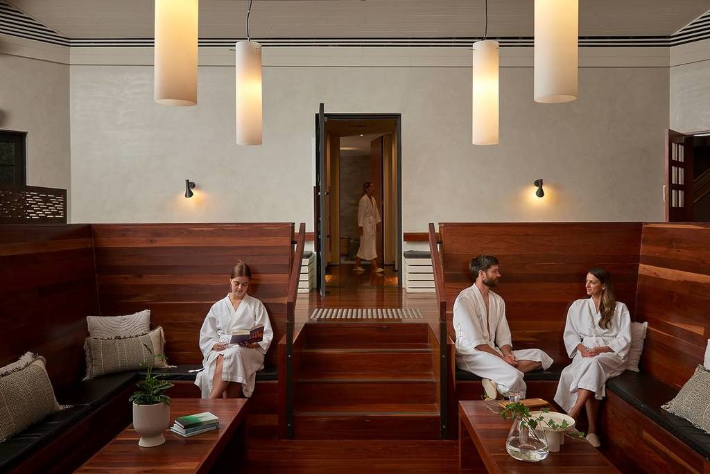 people in robes sitting in a waiting area at Hepburn Bathhouse & Spa