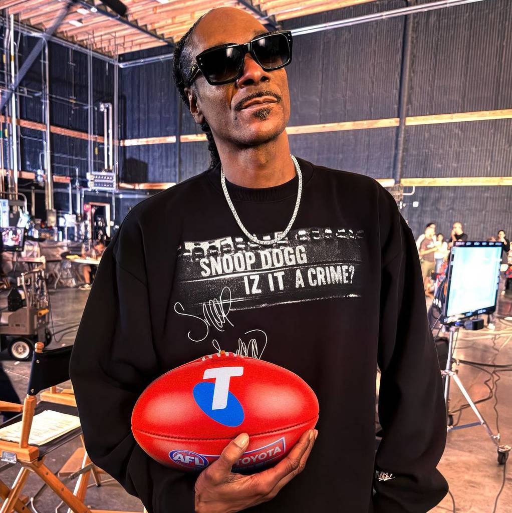 Snoop Dogg holding a footy to promote his AFL Grand Final performance