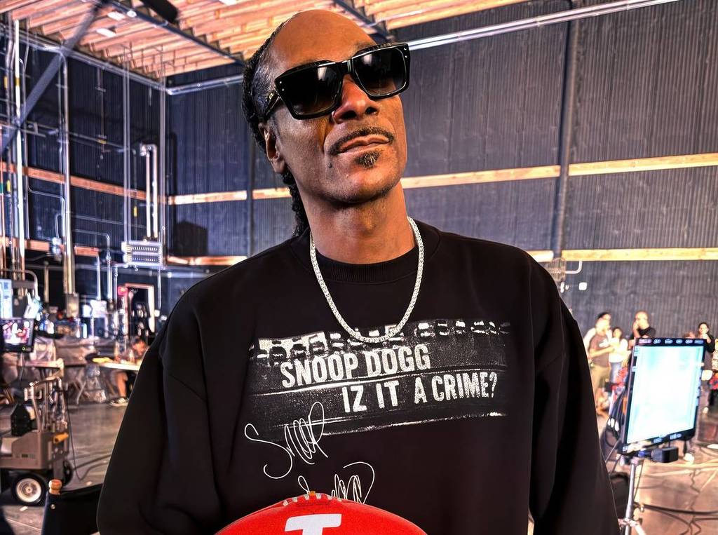 Snoop Dogg holding a footy to promote his AFL Grand Final performance