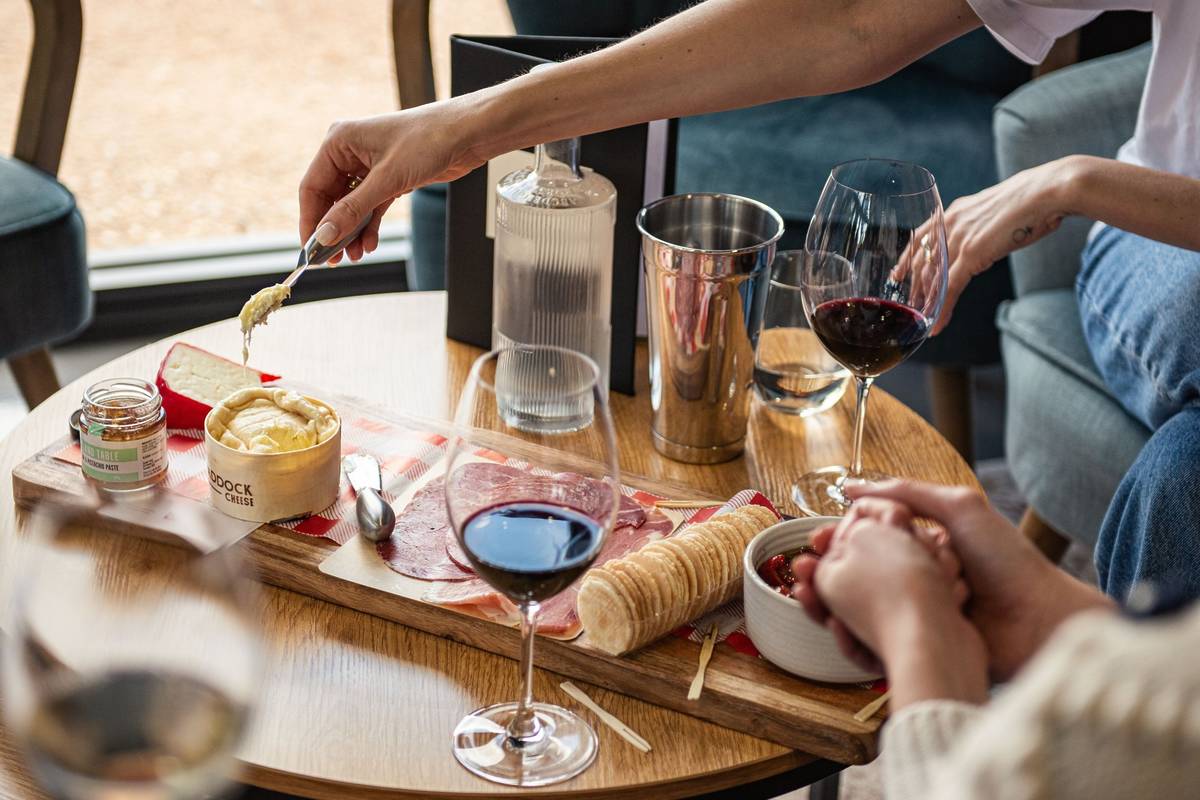 A shared charcuterie board with cheese, crackers, cured meats, and wine at a winery in Heathcote, one of the best offbeat towns in Victoria