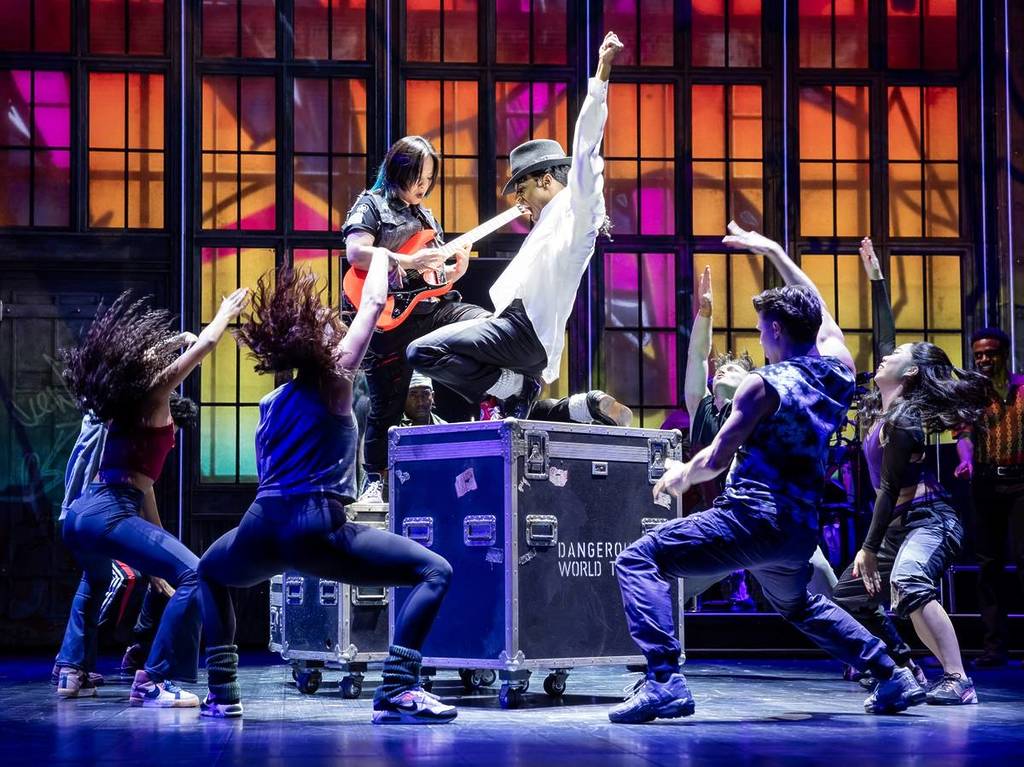 actor playing Michael Jackson surrounded by cast members in MJ the Musical