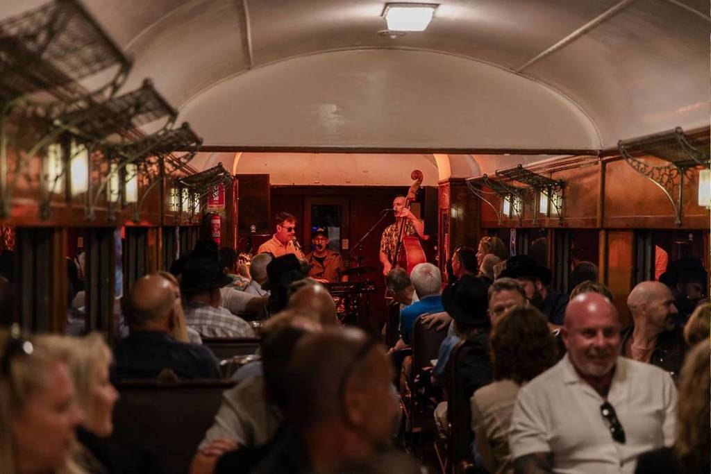 musicians playing in crowded train carriage on The Blues Train at night