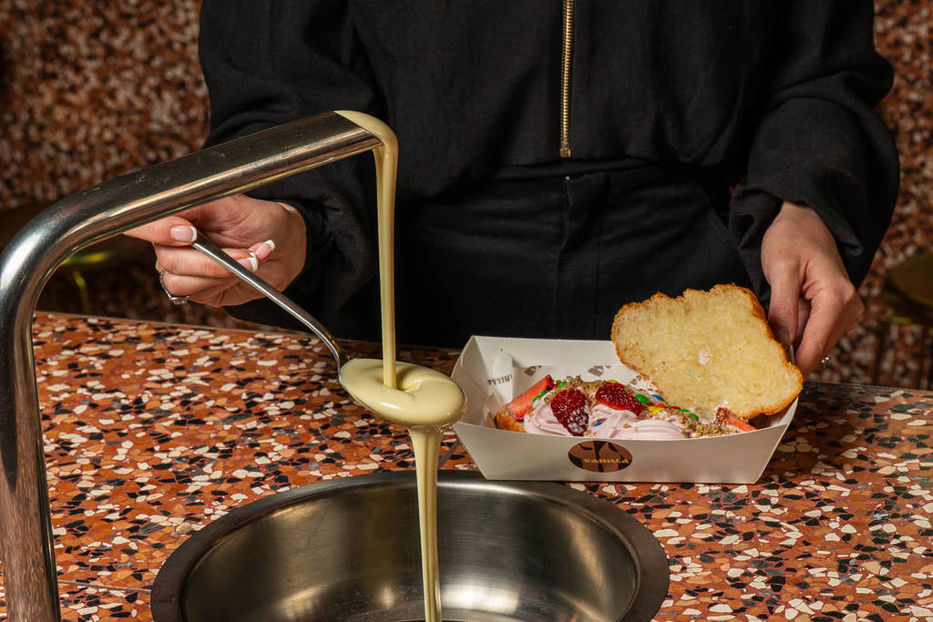 a cream-coloured chocolate sauce or custard coming out of a fountain to put onto a croissant at Vanilla Dessert Bar