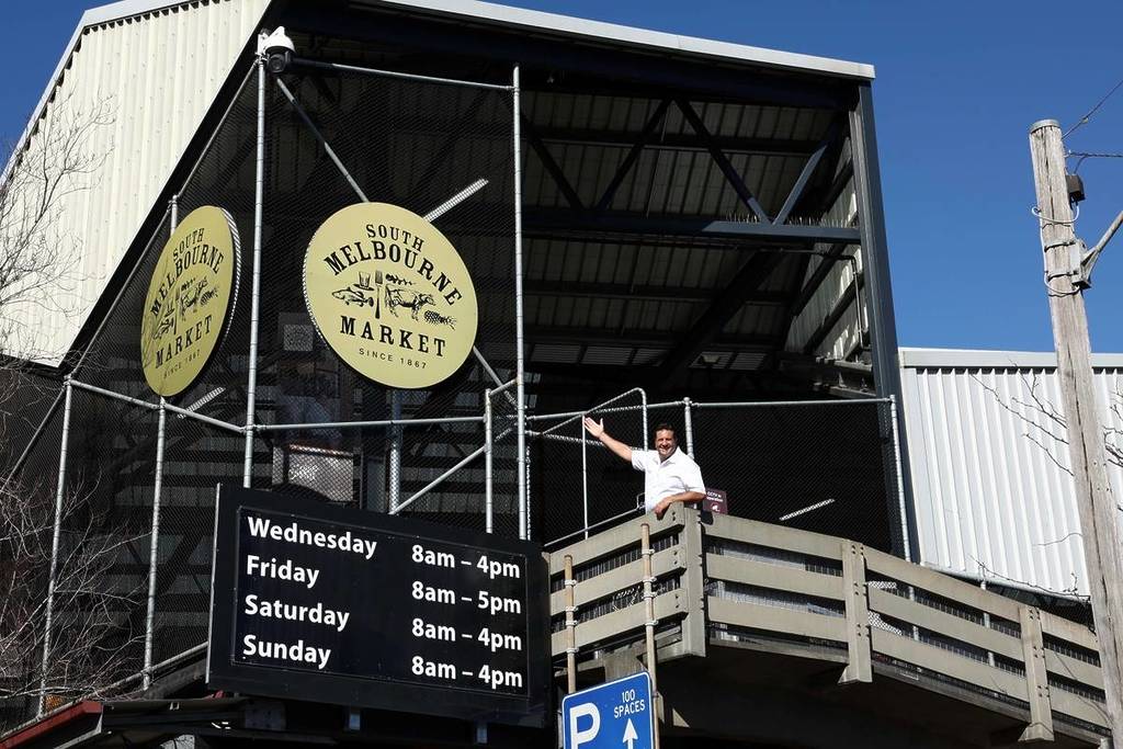 man pointing at South Melbourne Market sign