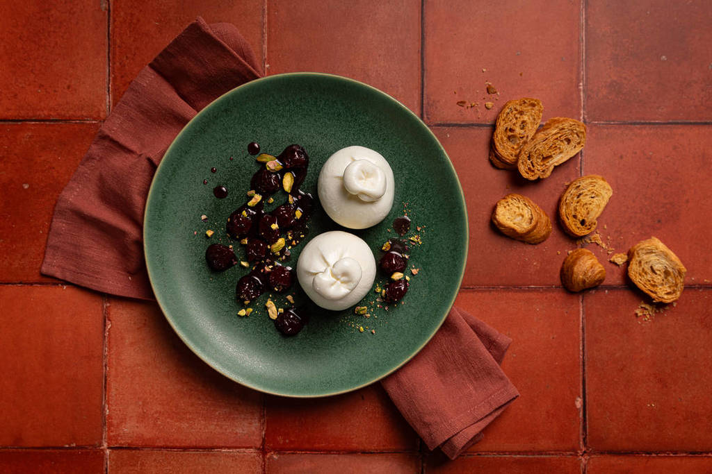 a plate of burrata and bread to the side