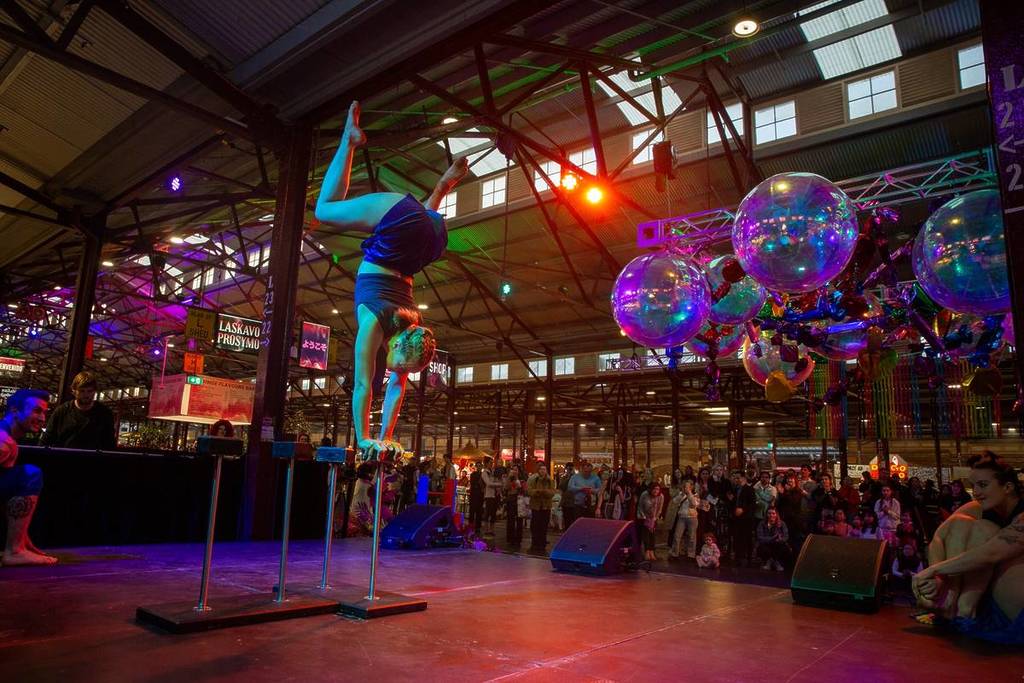 circus performer doing a handstand from a bar stool at Fringe Flavours Night Market