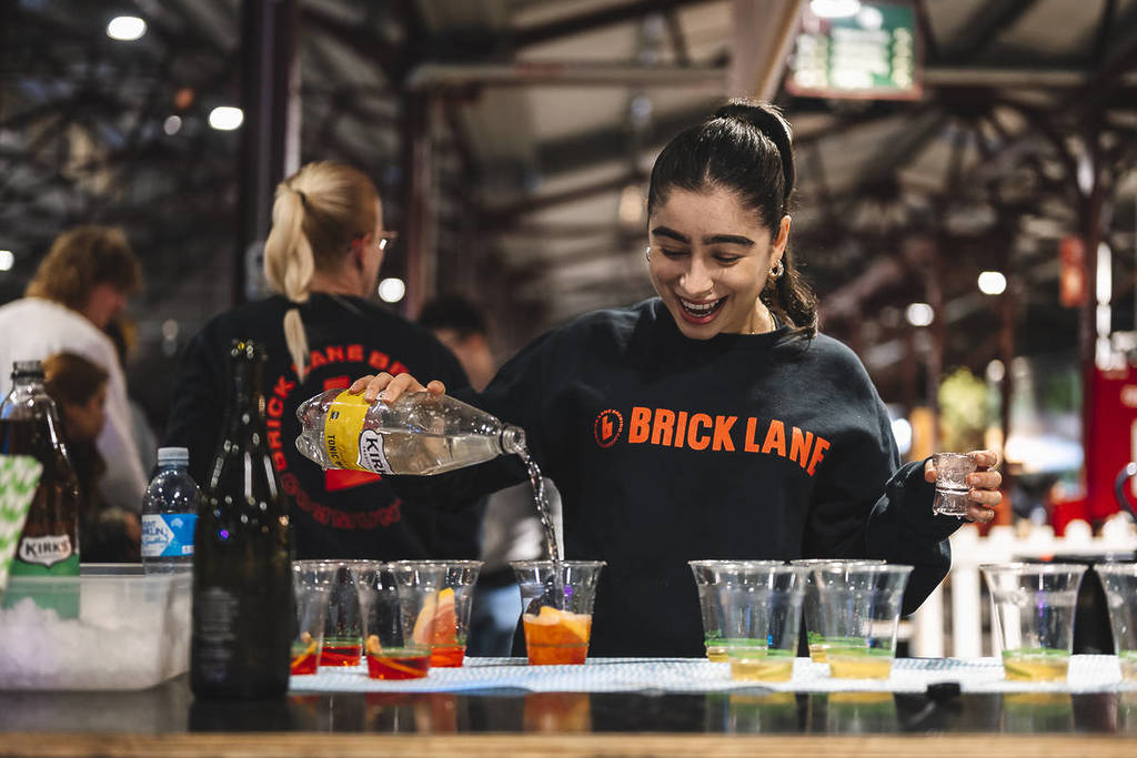 woman from Brick Lane Brewing pouring drinks at Queen Victoria Market