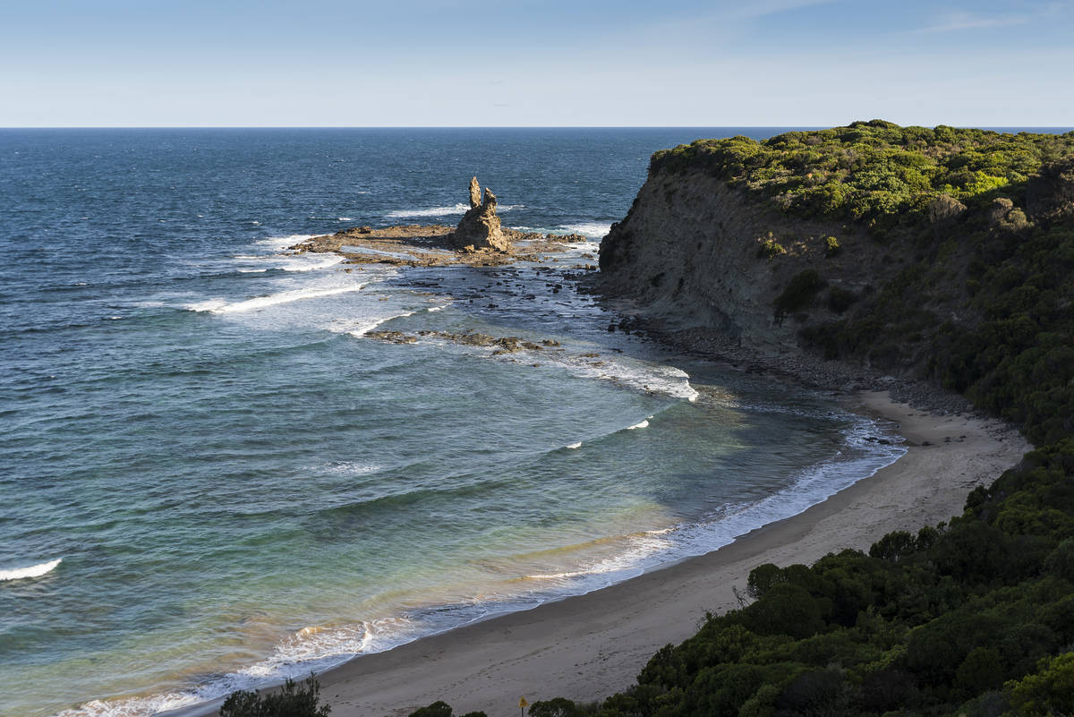 Eagle's Nest at Inverloch, showcasing a rocky coastline, clear blue waters, and lush greenery along the shore