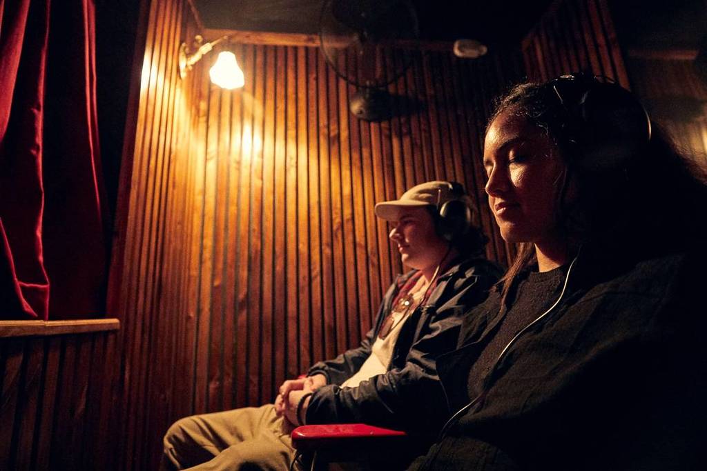 two audience members at Darkfield listening to something on headsets