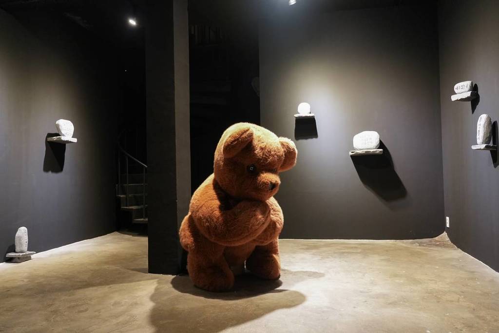 a large brown teddy bear in the middle of a room