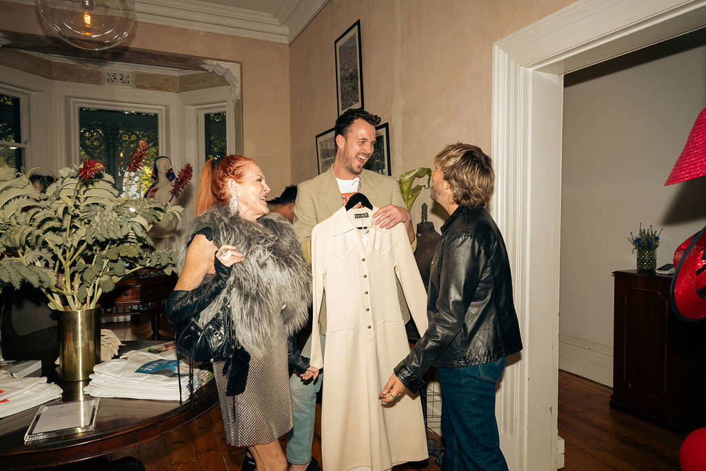 people laughing and holding a fancy coat inside Tasma Terrace