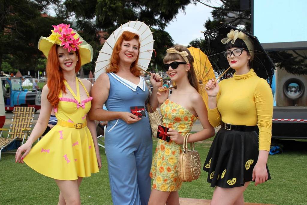four women wearing bright vintage clothes