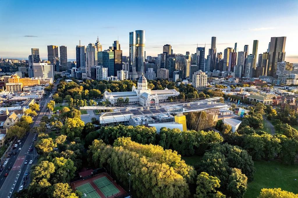 a view of the Melbourne skyline and Royal Exhibition Building from a distance above