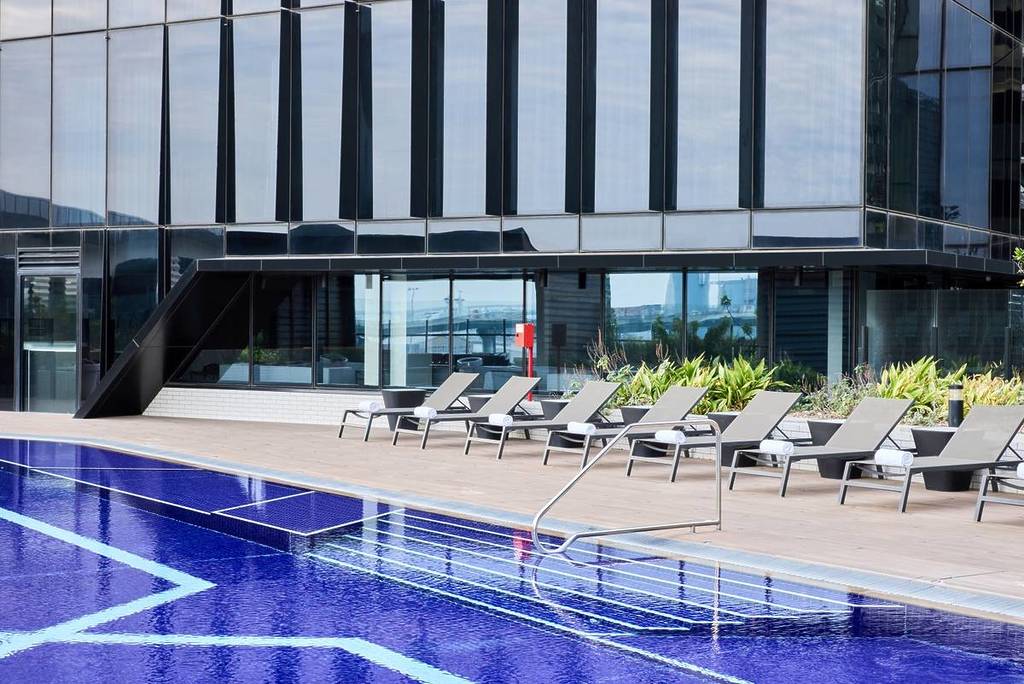 the sunbeds next to the pool at Vibe Hotel Docklands