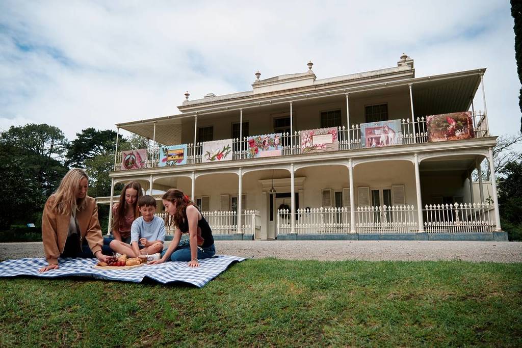 a family having a picnic on the lawn in front of COmo House