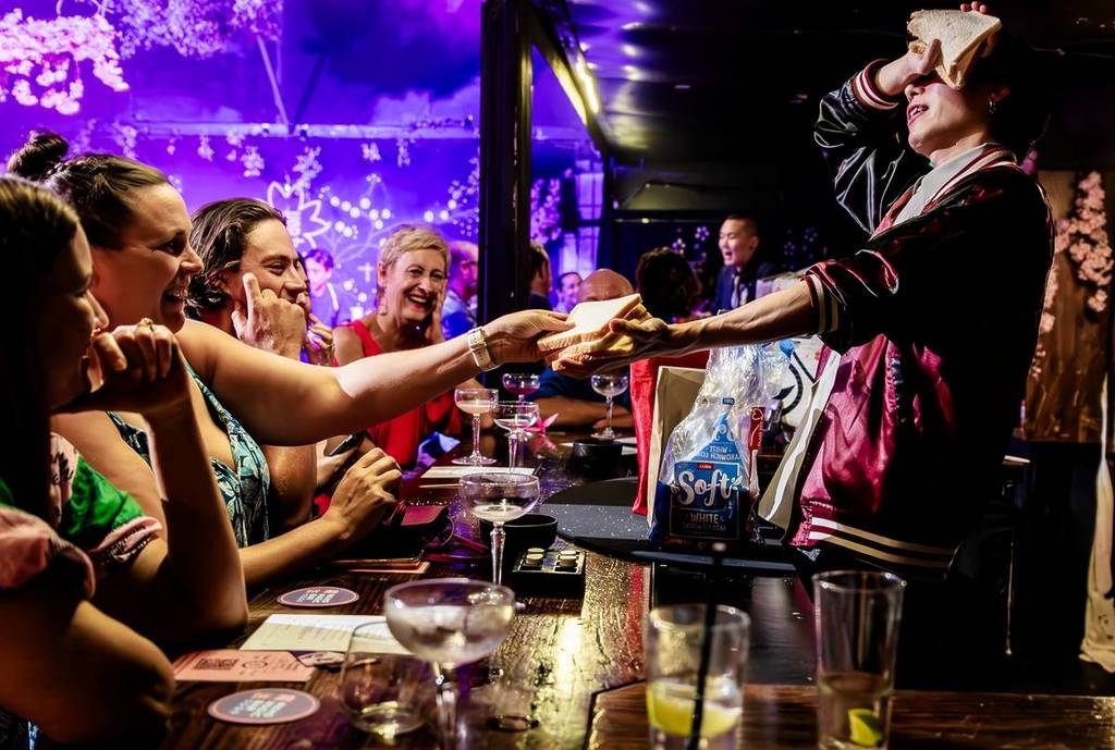 magician entertaining spectators with a sandwich at Maho Magic Bar