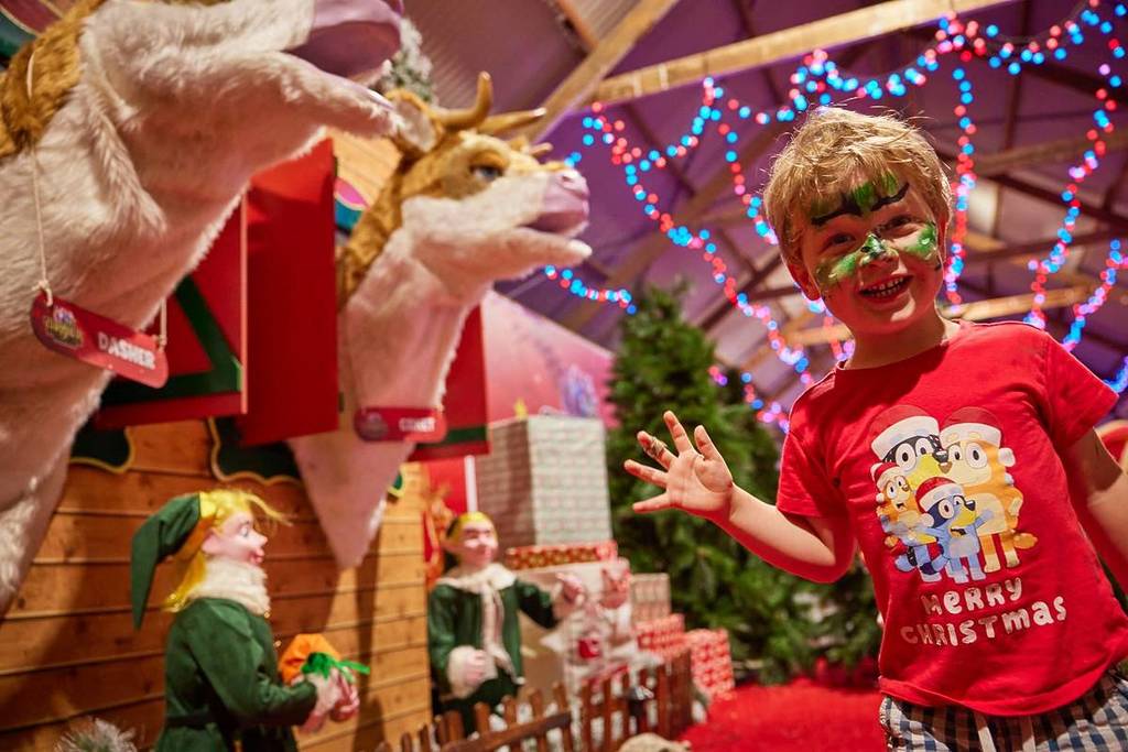 child waving in front of singing reindeer