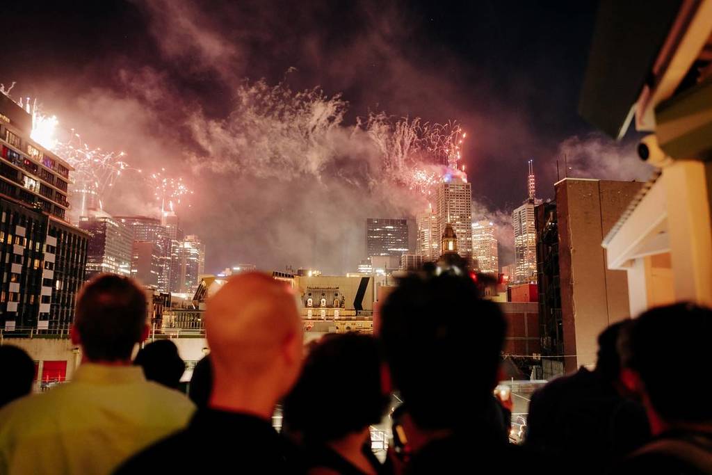 people on the rooftop of Hotel Nacional looking at the fireworks in Melbourne on New Year's Eve
