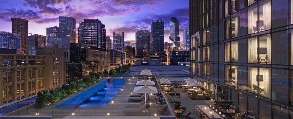 the rooftop pool at Le Meredien at sunset with a view of the city skyline