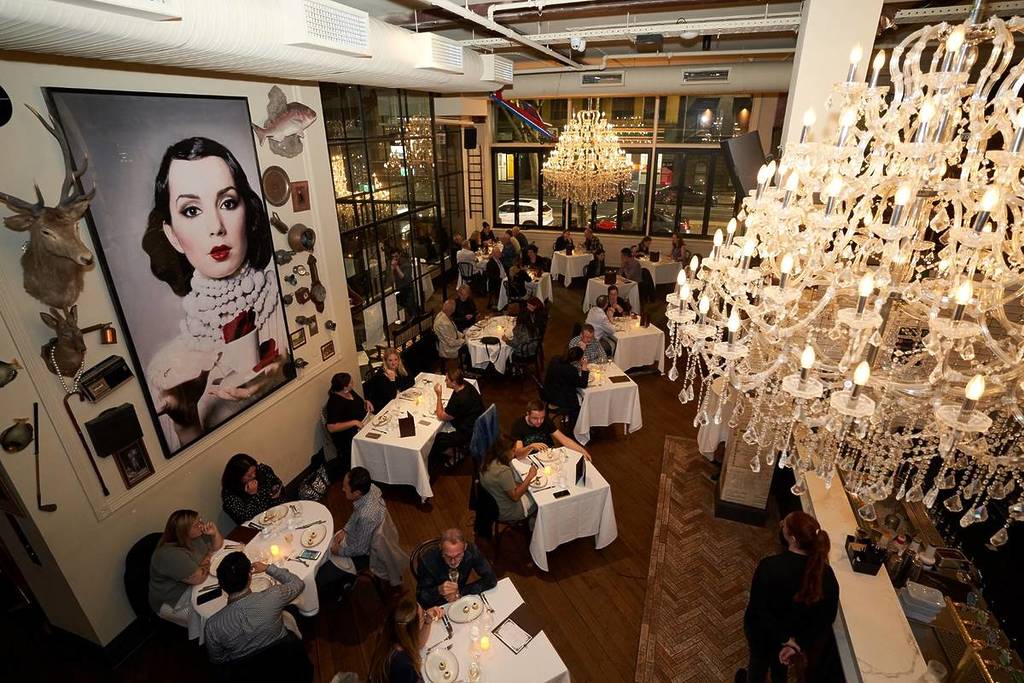 view of people dining under chandelier at State of Grace