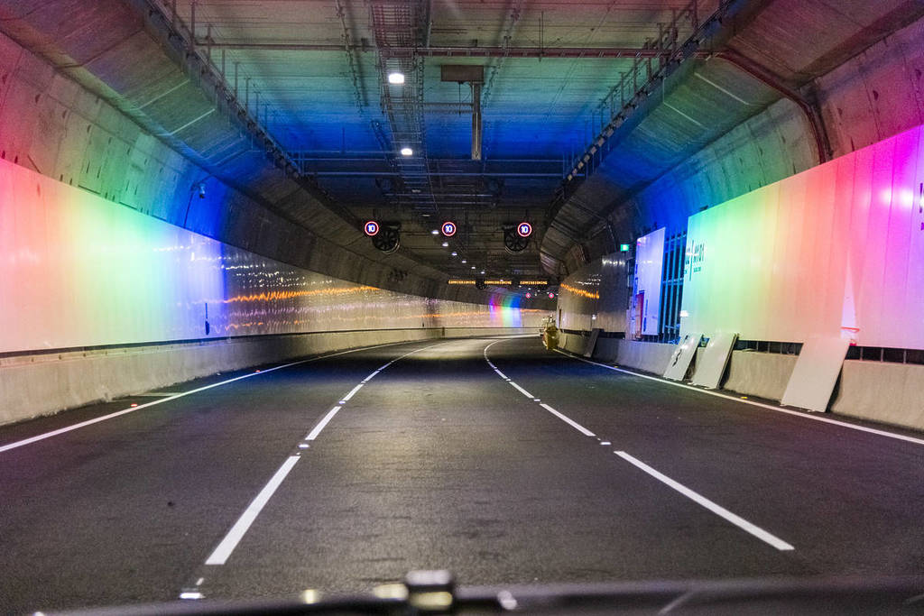 on the road inside the West Gate Tunnel, with rainbow lights on the walls