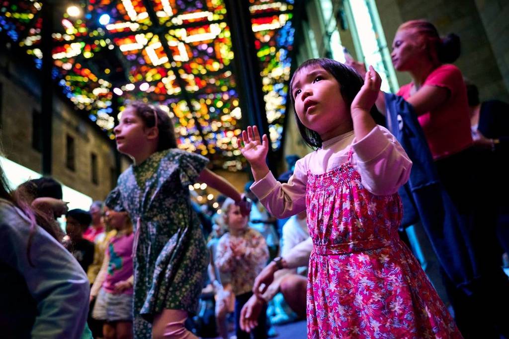 children dancing and watching something in the Great Hall at NGV