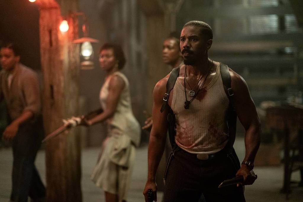Michael B Jordan as his character in Sinners, with other characters in the background