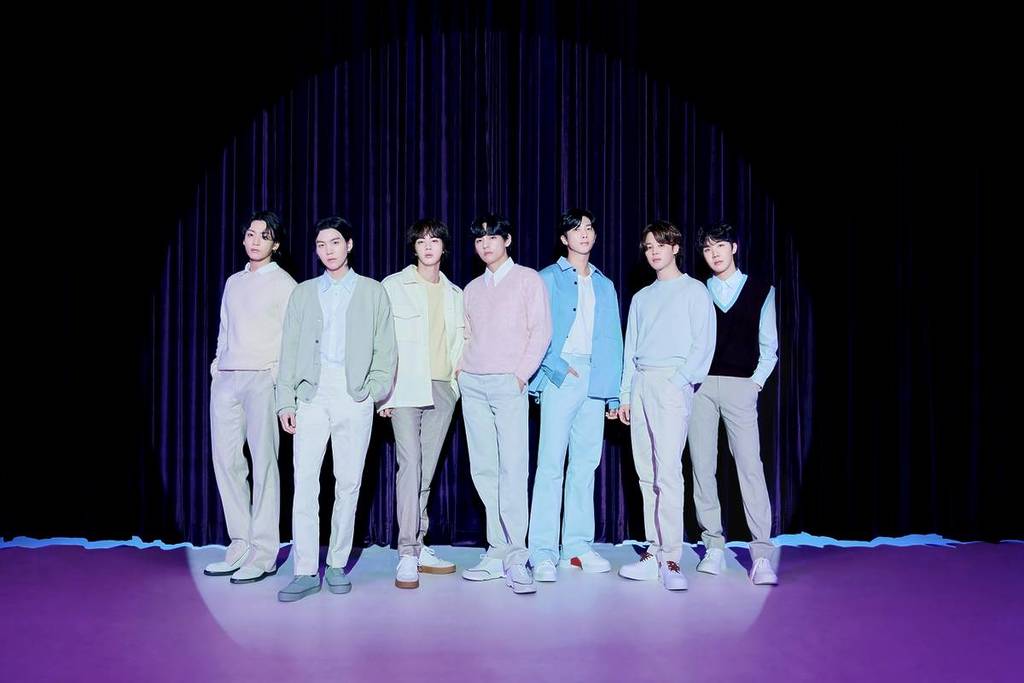 BTS in pastel outfits in a spotlight