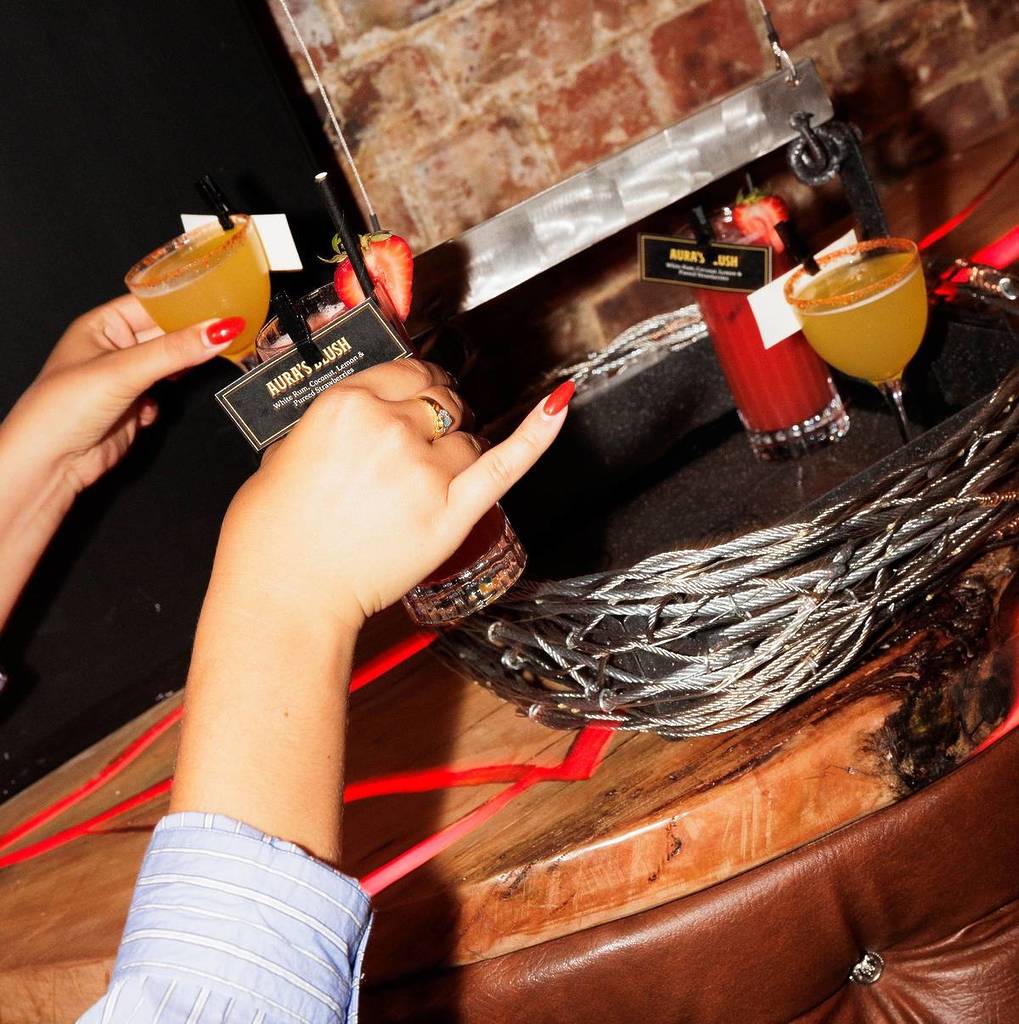 women taking their cocktails from a basket delivered via zipline at Arcane Fairies