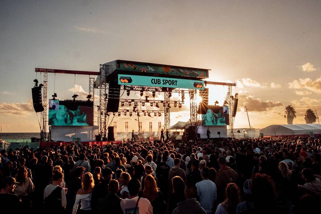 sunset at St Kilda Festival, with big crowds watching a performance on stage