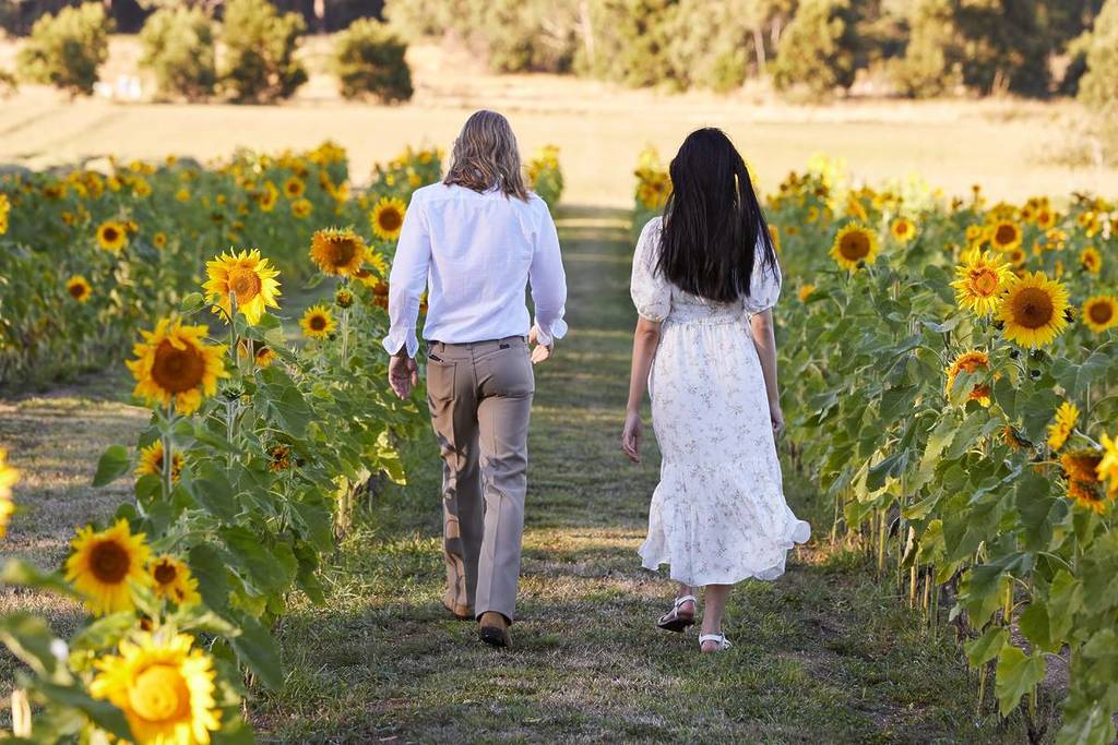 two women walking among wide rows of sunflowers at Sault restaurant in Daylesford