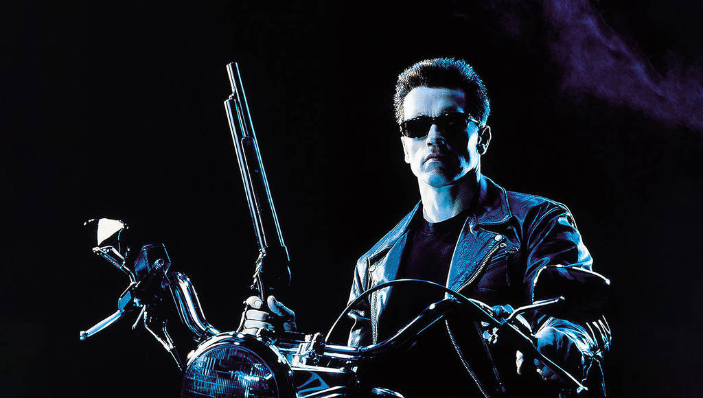 The Terminator in the second film on a motorbike wearing sunnies and holding a gun