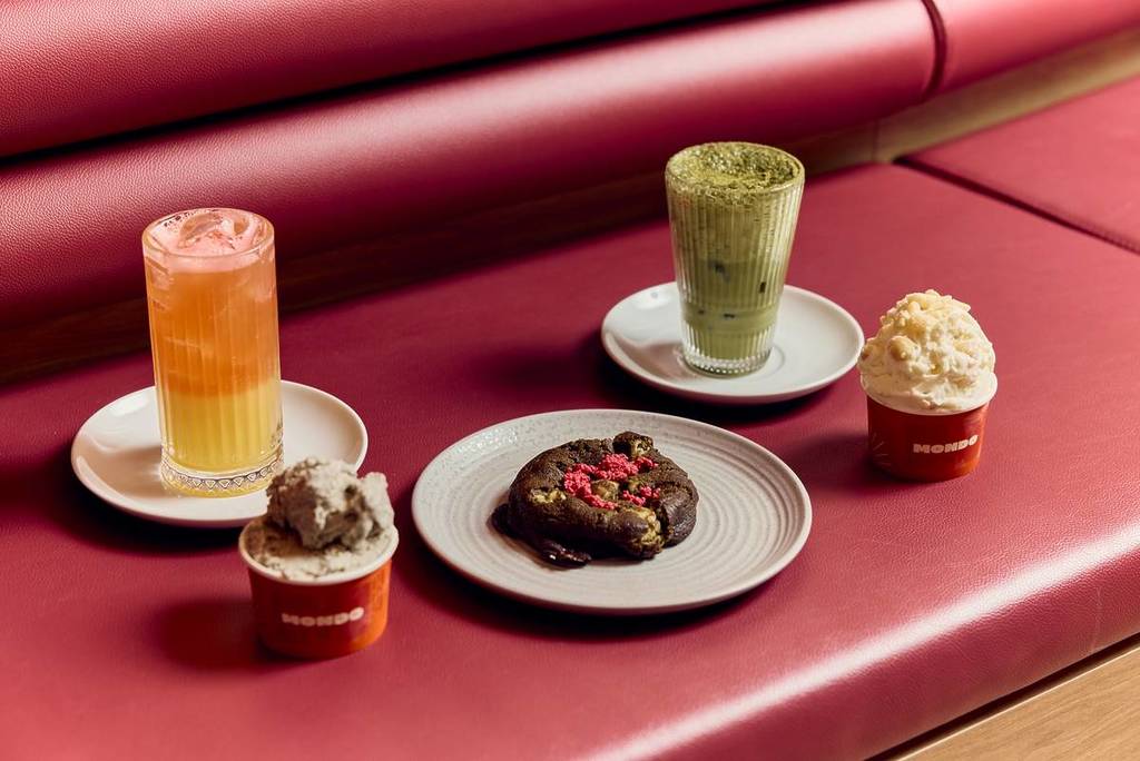 a loaded cookie and some gelato scoops as well as colourful drinks on a banquette