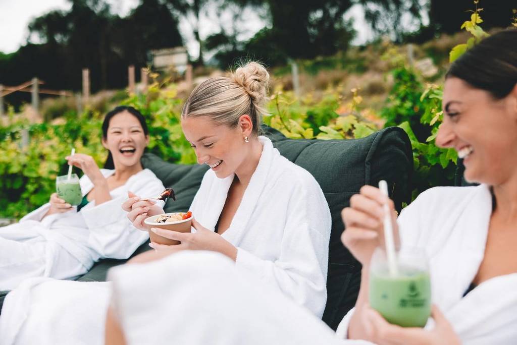 three women sipping on cool drinks or eating an acai bowl at Peninsula Hot Springs