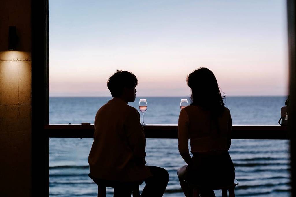 two people drinking wine looking out over the ocean at Stokehouse