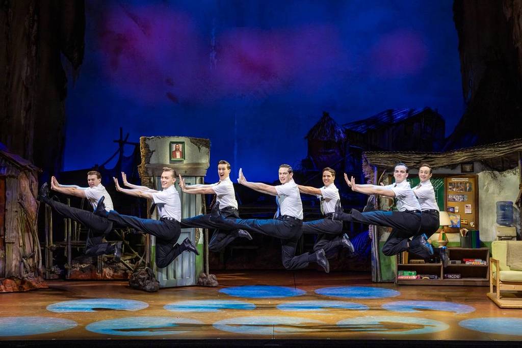 the cast of the Book of Mormon jumping in mid-air