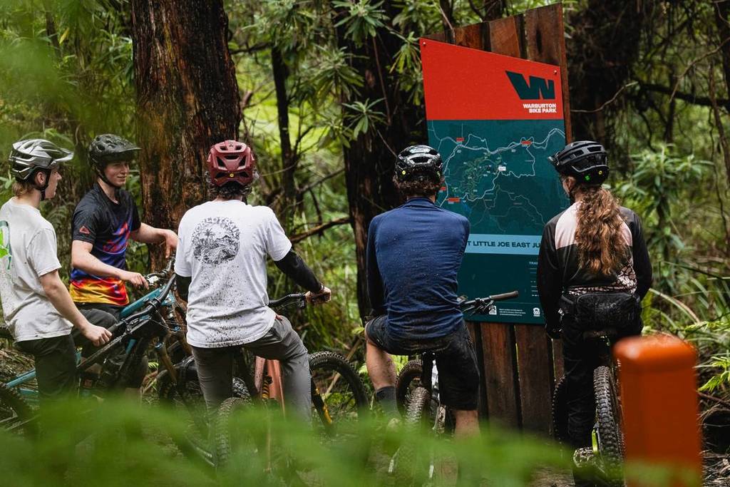 group of riders looping at the trail network map at Warburton Bike Park